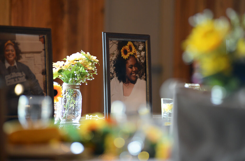 Framed photographs of Tyus Monroe rest on tables
